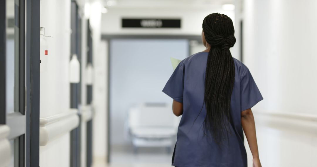 Female Nurse Walking Through Hospital Corridor - Free Images, Stock Photos and Pictures on Pikwizard.com