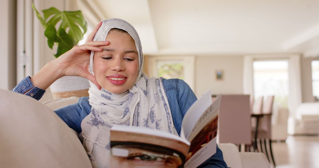 Muslim Woman Reading Book on Couch at Home - Free Images, Stock Photos and Pictures on Pikwizard.com