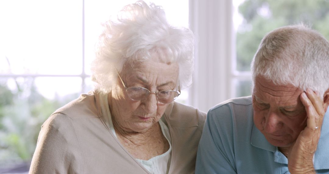 Senior Couple Contemplating at Home by Window