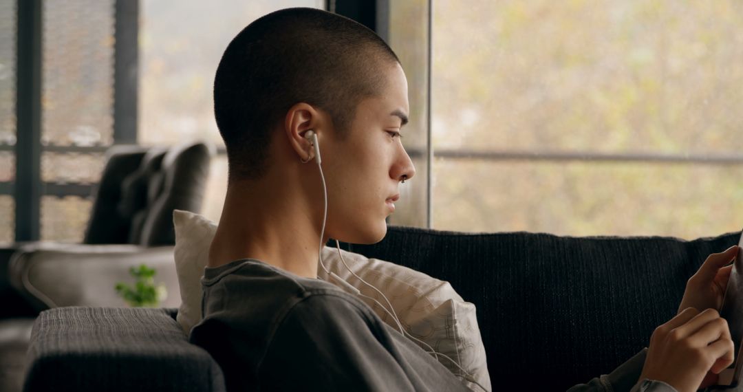 Young Person Listening to Music with Earbuds at Home - Free Images, Stock Photos and Pictures on Pikwizard.com