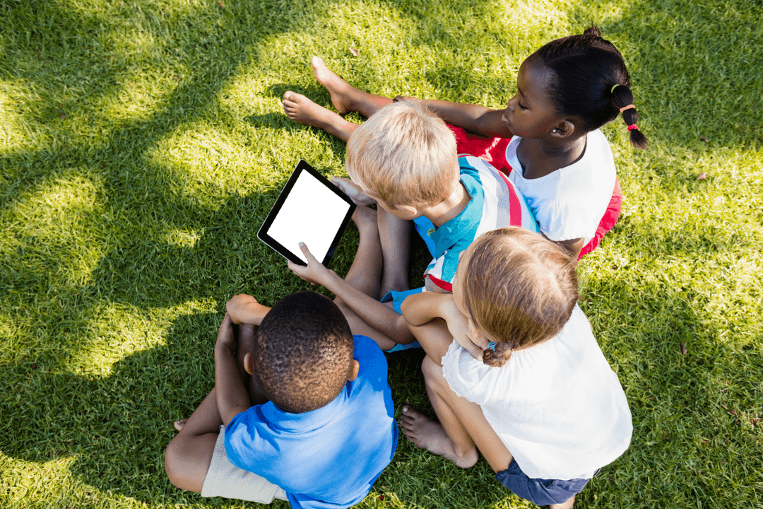 Diverse Children Using Transparent Tablet Outdoors in Park