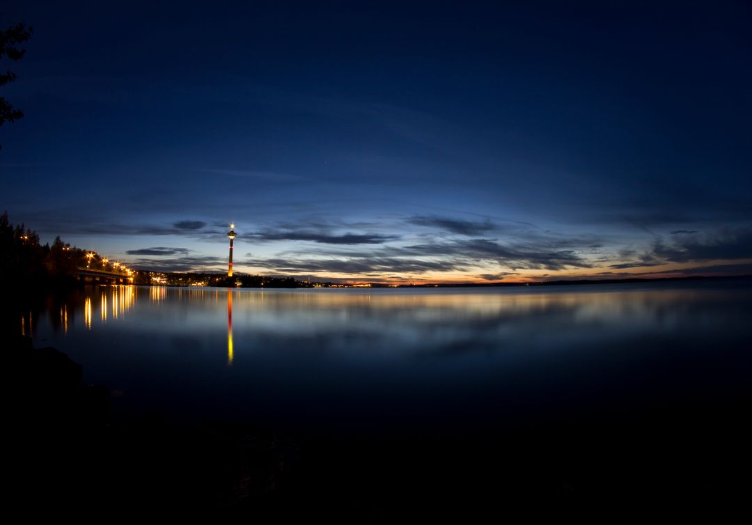 Scenic Sunset Over Calm Lake with Distant City Lights - Free Images, Stock Photos and Pictures on Pikwizard.com