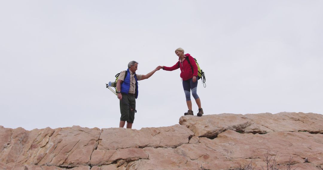 Man and Woman Hiking on Rocky Terrain Hand in Hand - Free Images, Stock Photos and Pictures on Pikwizard.com