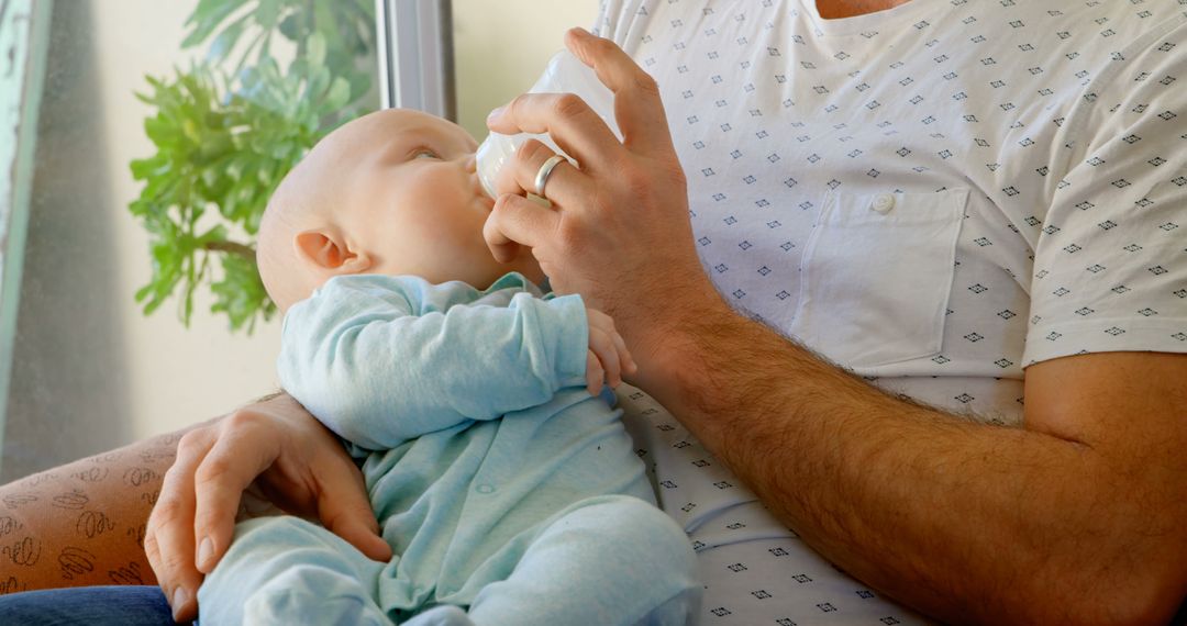 Father feeding baby with bottle at home - Free Images, Stock Photos and Pictures on Pikwizard.com