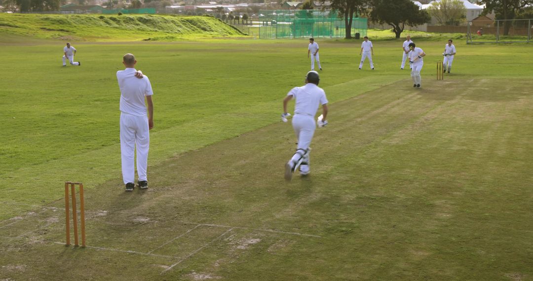 Outdoor Cricket Match with Batsman Running between Wickets