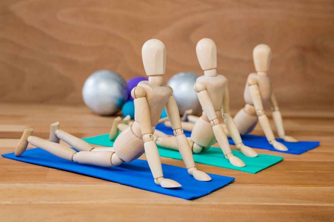 Wooden Mannequins Stretching on Yoga Mats - Free Images, Stock Photos and Pictures on Pikwizard.com