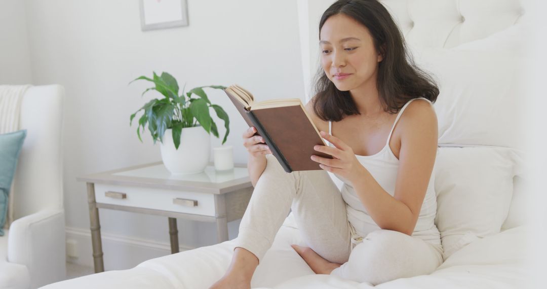 Young Woman Reading Book in Cozy Bedroom - Free Images, Stock Photos and Pictures on Pikwizard.com