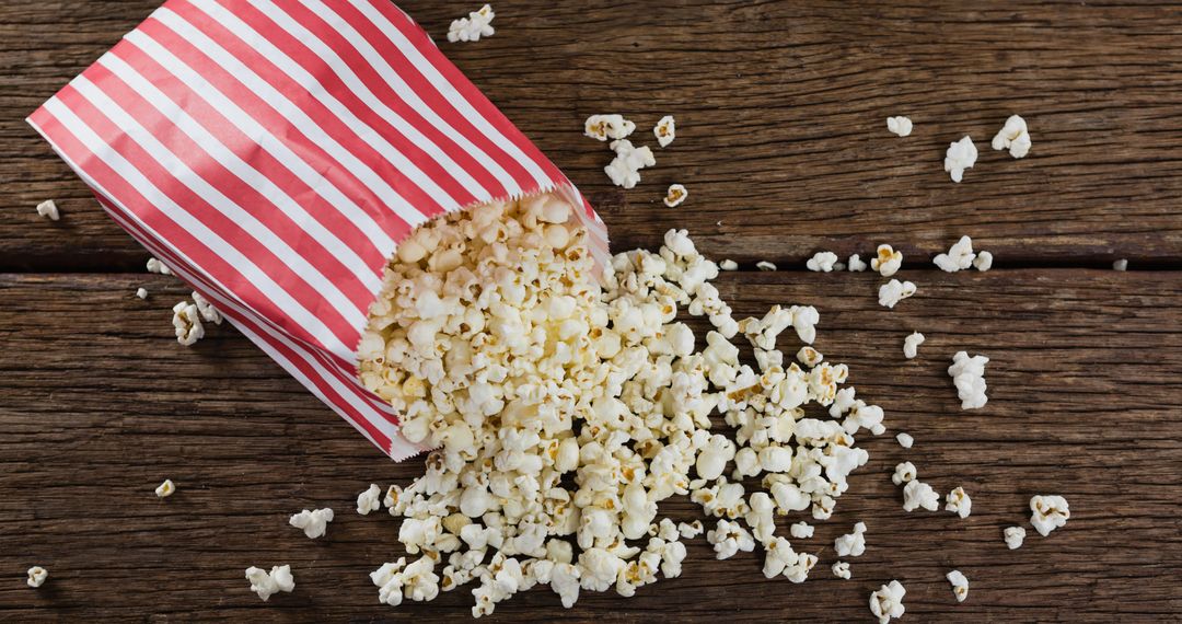 Freshly Popped Popcorn in Striped Box on Rustic Wooden Table