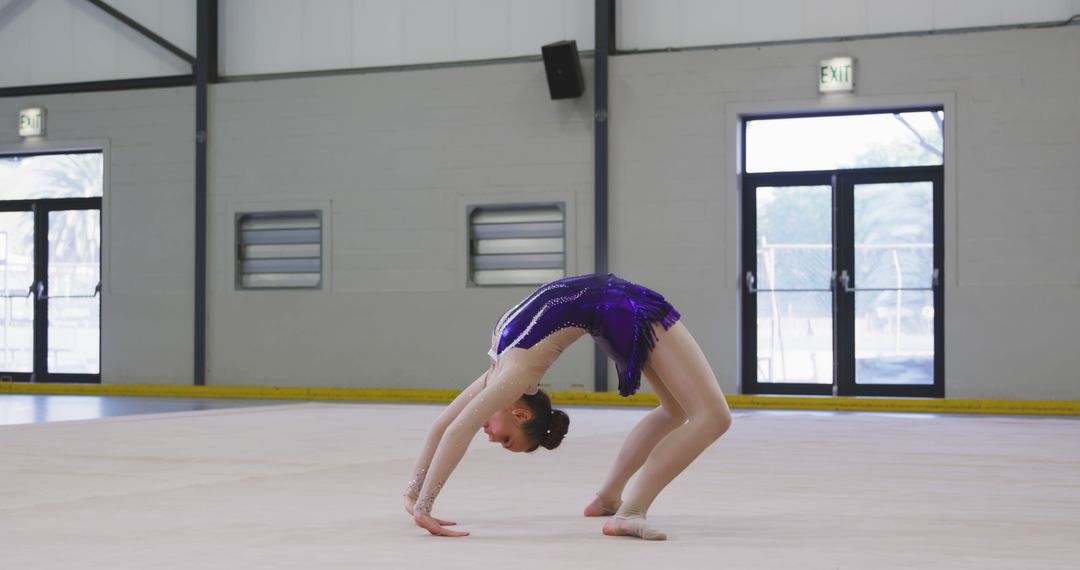 Gymnast Performing Flexibility Routine in Sports Hall