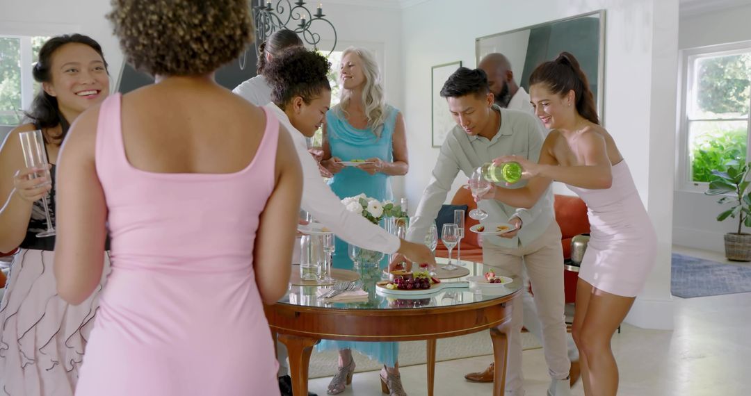 Multicultural friends pouring sparkling wine and sharing hors d'oeuvres at elegant party