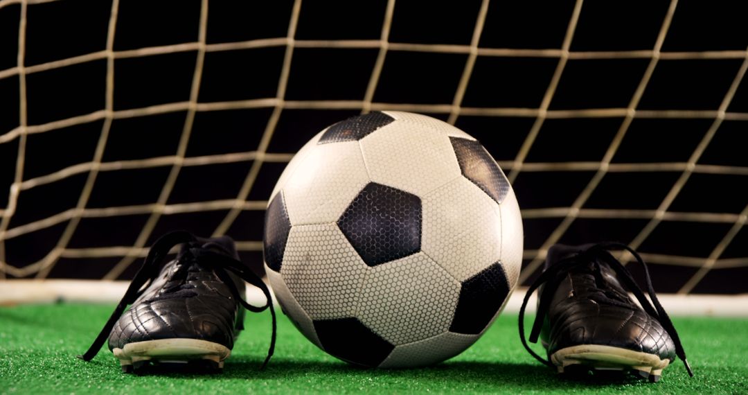 Soccer Ball and Cleats on Green Field with Goal Net in Background - Free Images, Stock Photos and Pictures on Pikwizard.com