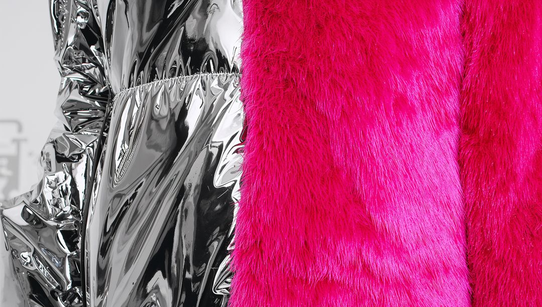 Showcasing silver metallic coat with vibrant fuchsia faux-fur panel close-up texture