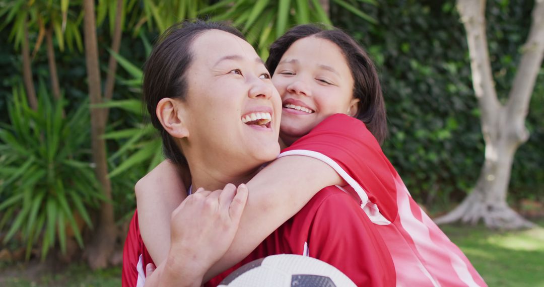 Happy Mother and Daughter Hugging Outdoors after Soccer Game - Free Images, Stock Photos and Pictures on Pikwizard.com