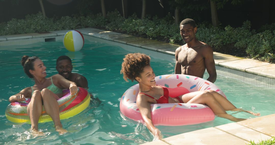 Diverse Friends Enjoying Summer Pool Fun with Inflatable Rings
