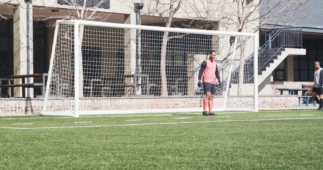 Soccer Player Standing by Goalpost on Sunny Day in Pink Jersey