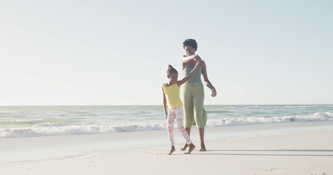 African American Mother and Daughter Walking on Sea Shore - Free Images, Stock Photos and Pictures on Pikwizard.com