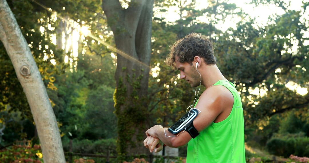 Young Athlete Checking Fitness Tracker in Green Sportswear - Free Images, Stock Photos and Pictures on Pikwizard.com