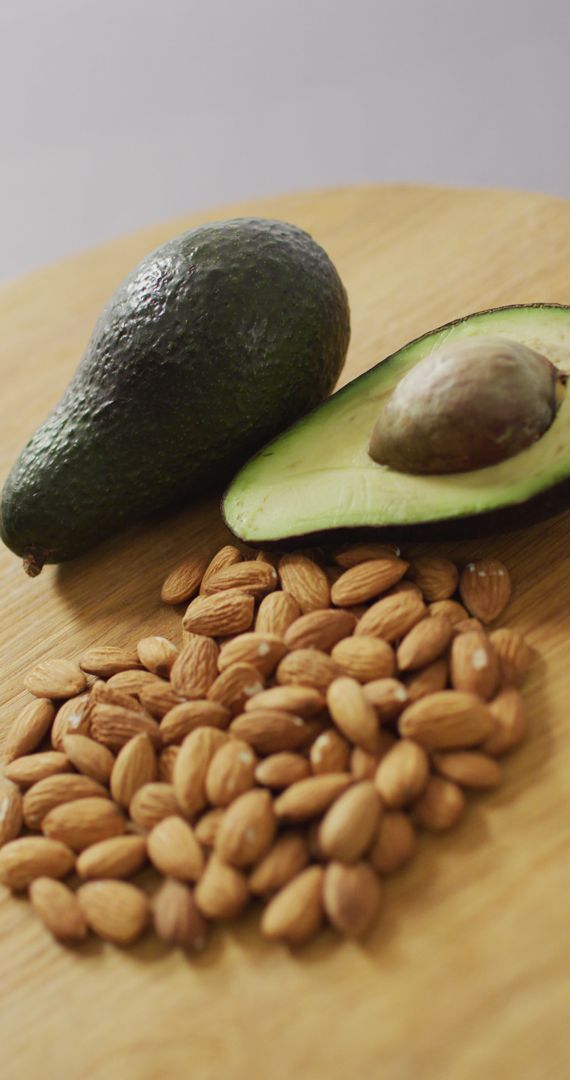 Almonds and Avocado on Wooden Surface Highlighting Nutritional Foods
