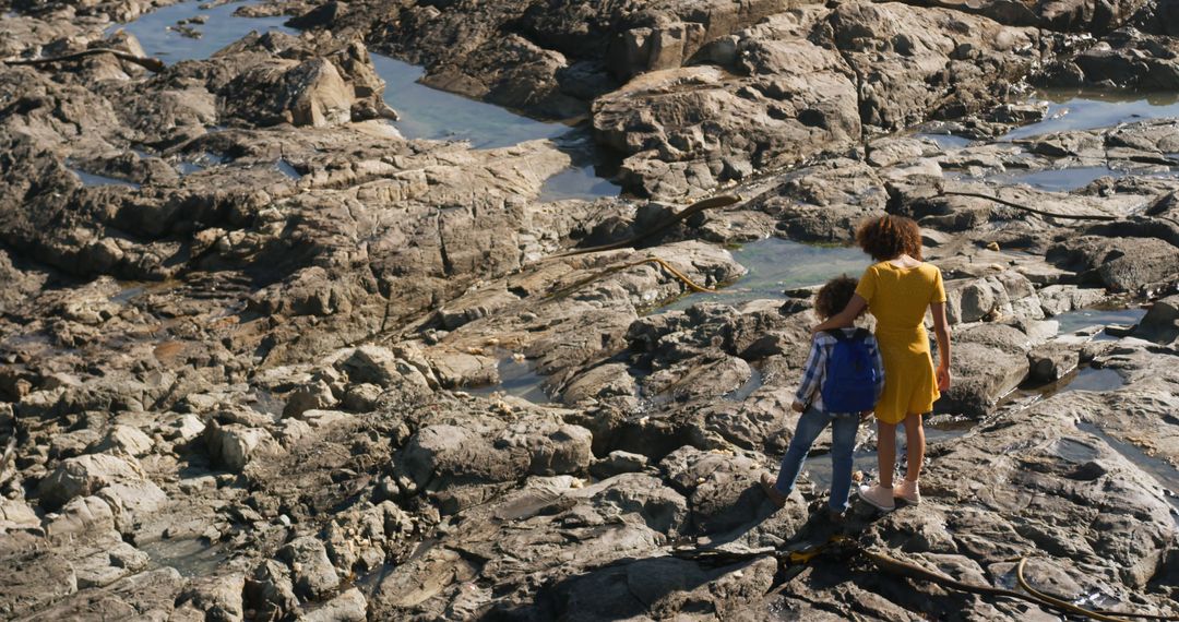 Mother and Son Standing on Rocky Beach in Sunny Weather - Free Images, Stock Photos and Pictures on Pikwizard.com