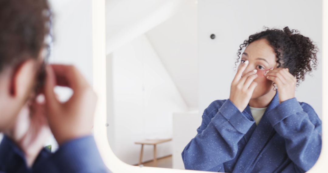 Woman Putting On Contact Lenses In front Of Mirror - Free Images, Stock Photos and Pictures on Pikwizard.com