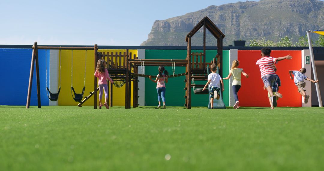 Kids Playing on Colorful Playground Set with Mountain View