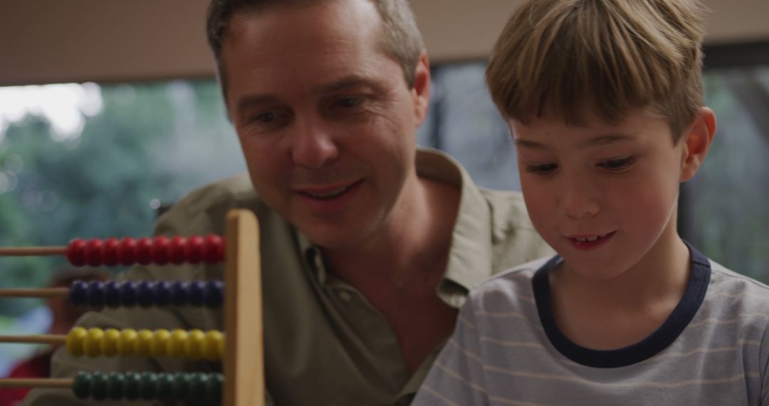 Father and son bonding while playing with abacus at home - Free Images, Stock Photos and Pictures on Pikwizard.com