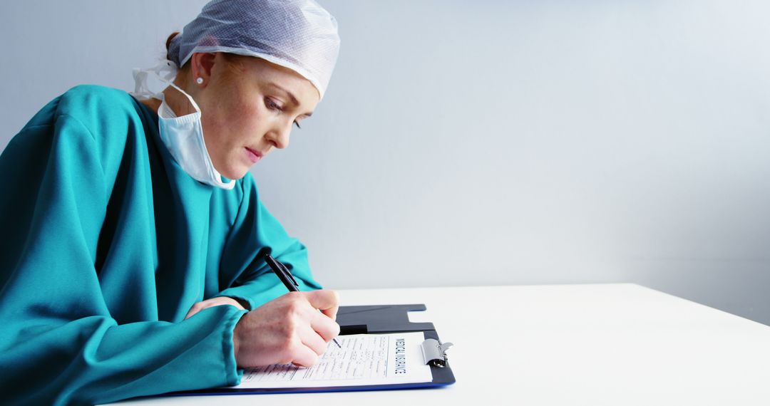 Medical Professional Writing on a Clipboard During Work - Free Images, Stock Photos and Pictures on Pikwizard.com