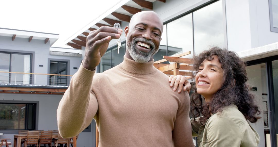 Portrait of happy biracial couple embracing and holding keys at new house - Free Images, Stock Photos and Pictures on Pikwizard.com