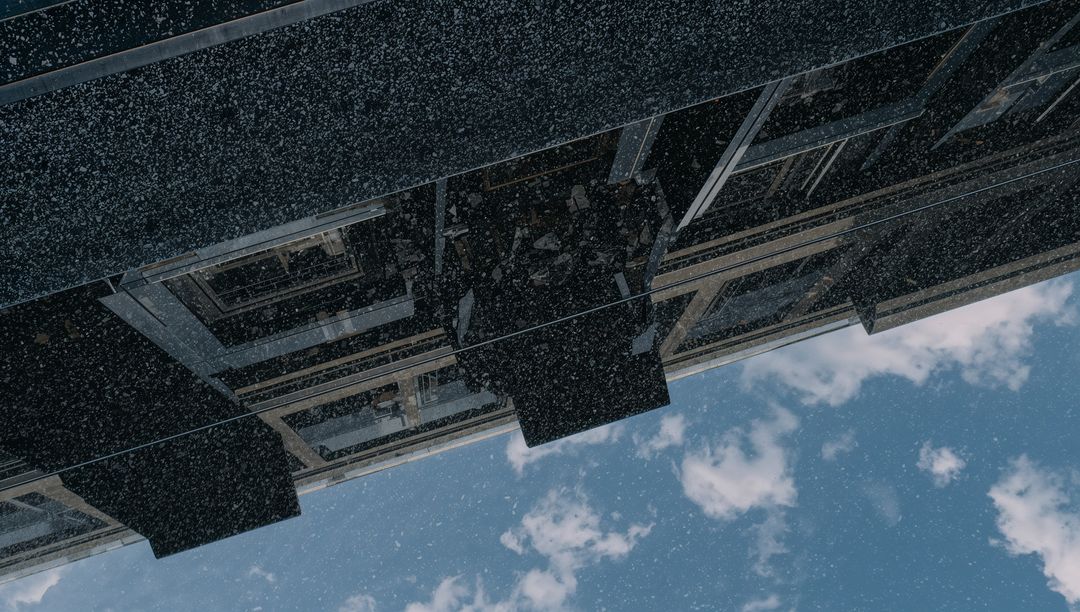 Diagonal Glass Facade Slanting Across Sky with Reflective Panels, Box Balconies, Snow