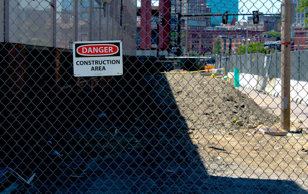 Construction Area Warning Sign Behind Chain Link Fence
