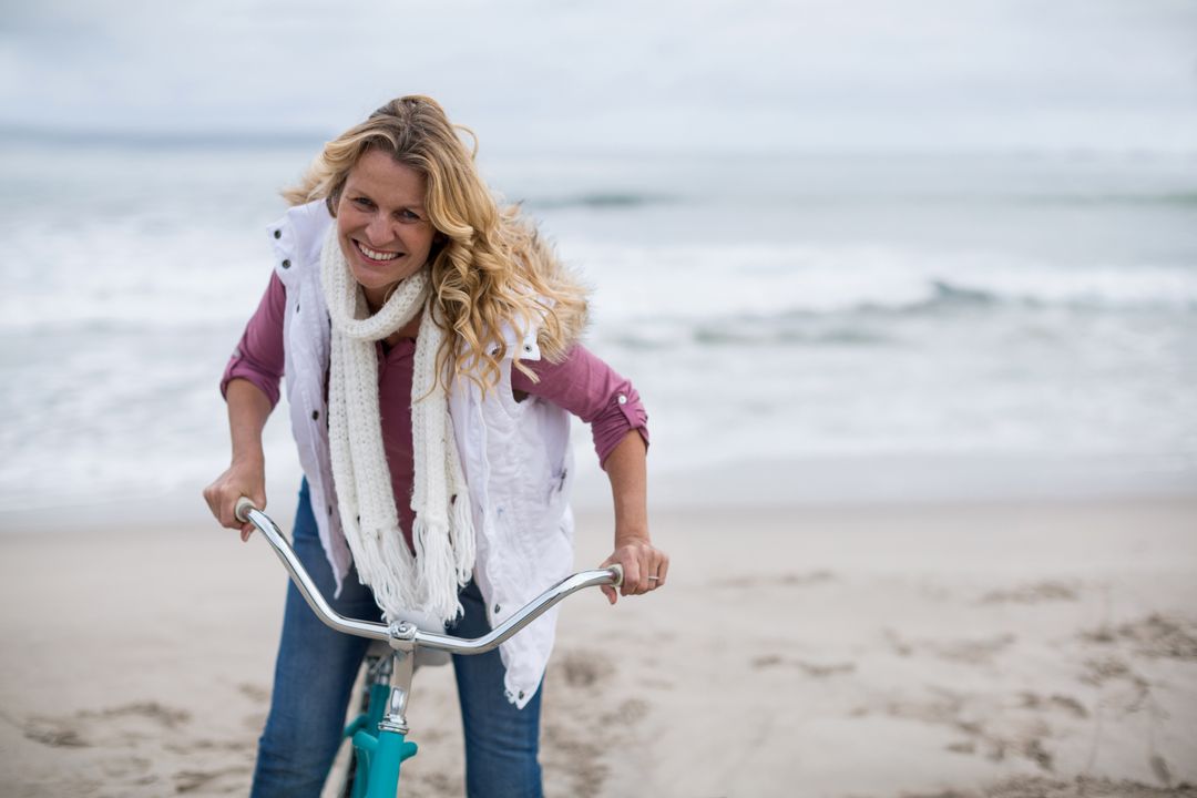 Smiling Woman Enjoying Bicycle Ride on Shoreline