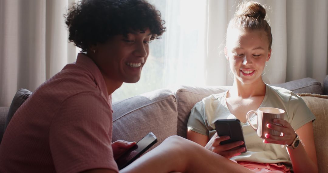 Relaxed Couple on Couch with Smartphones and Coffee