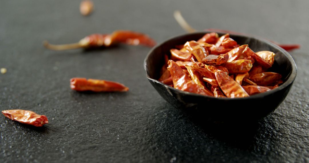 Dried Red Chili Peppers in Black Bowl on Dark Slate Background - Free Images, Stock Photos and Pictures on Pikwizard.com