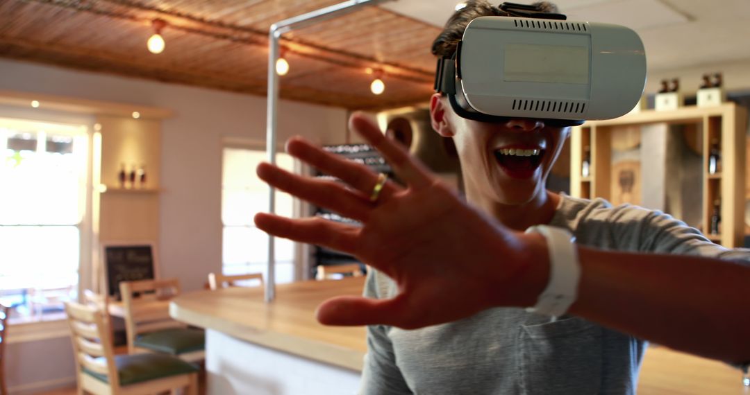 Man Enthusiastically Experiencing Virtual Reality Inside Modern Apartment - Free Images, Stock Photos and Pictures on Pikwizard.com