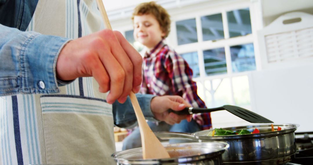 Father and Son Cooking Together in Bright Modern Kitchen - Free Images, Stock Photos and Pictures on Pikwizard.com