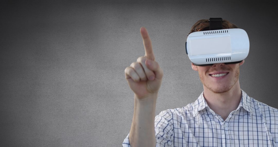 Man Using Virtual Reality Headset Against Grey Background