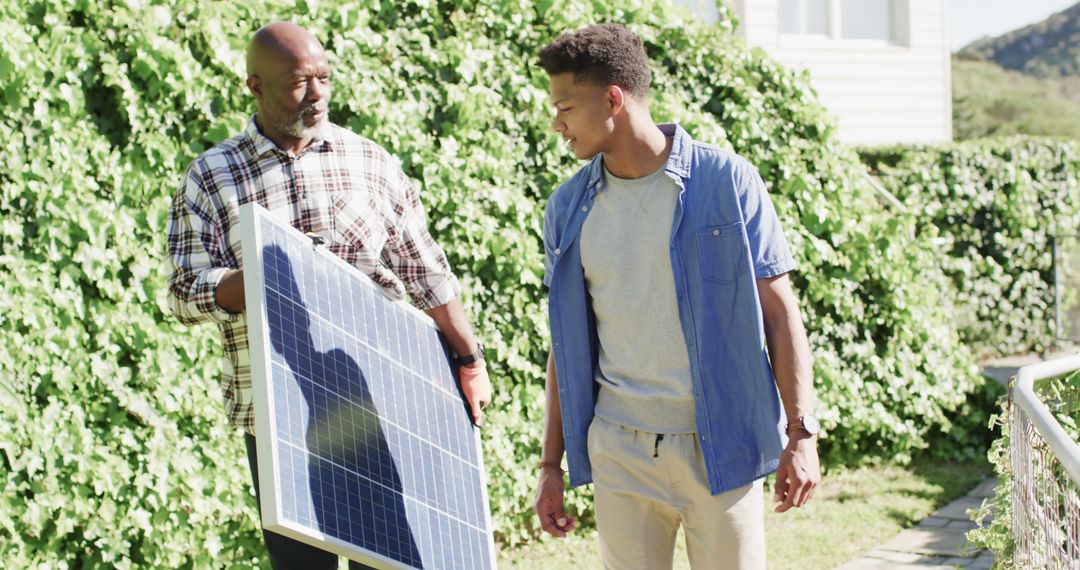 Father and Son Collaborating on Solar Panel Installation Outdoors - Free Images, Stock Photos and Pictures on Pikwizard.com