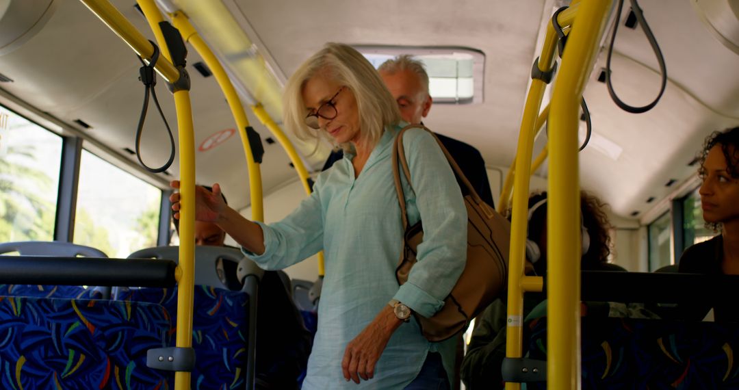 Senior woman standing in public bus during commute - Free Images, Stock Photos and Pictures on Pikwizard.com