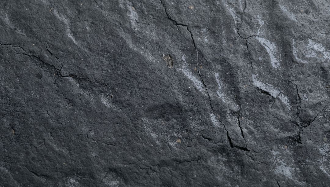 Dark Slate Rock Texture with Cracks and Mineral Veins for Natural Backgrounds