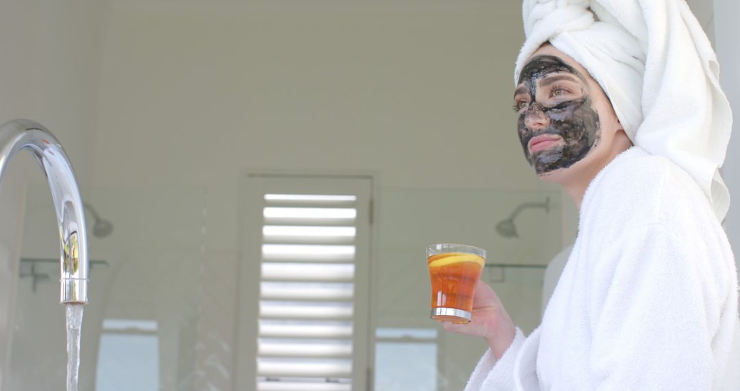 Woman Relaxing with Facial Mask and Drink in Bathrobe - Free Images, Stock Photos and Pictures on Pikwizard.com