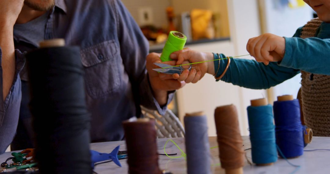 Father and Son Engaging in Creative Thread Crafting at Home