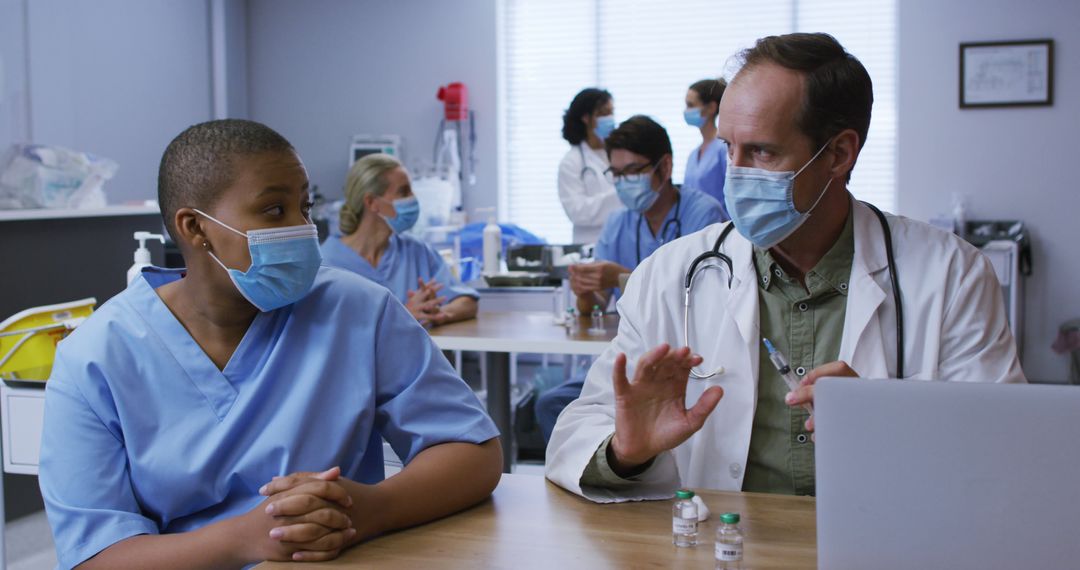 Medical Staff Discussing in Hospital Room Using Protective Face Masks - Free Images, Stock Photos and Pictures on Pikwizard.com