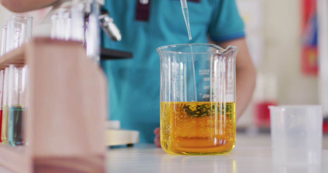 Student Conducting Chemistry Experiment with Yellow Liquid in Laboratory - Free Images, Stock Photos and Pictures on Pikwizard.com