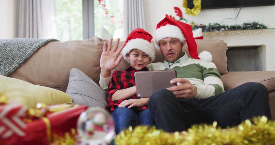 Father and son video calling family during Christmas celebration at home - Free Images, Stock Photos and Pictures on Pikwizard.com