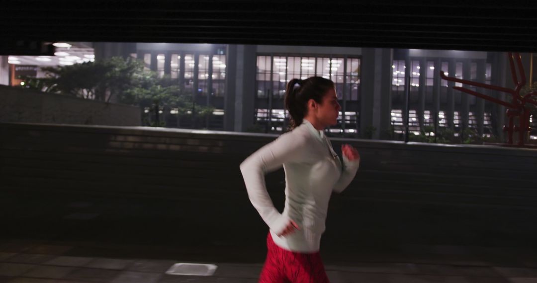 A fit woman with dark hair jogs in city at night in sportswear. - Free Images, Stock Photos and Pictures on Pikwizard.com