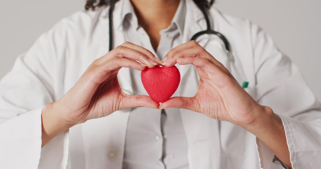 Image of biracial female doctor holding heart on white background - Free Images, Stock Photos and Pictures on Pikwizard.com