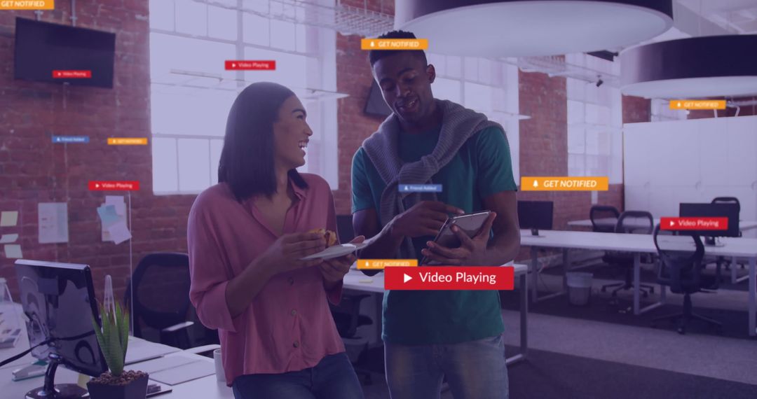 Colleagues Discussing Tech with Social Media Graphics in Modern Office