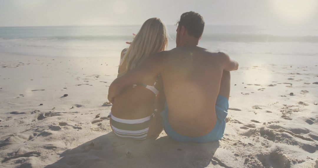 Couple Relaxing on Sunlit Sandy Beach Embracing Tranquility