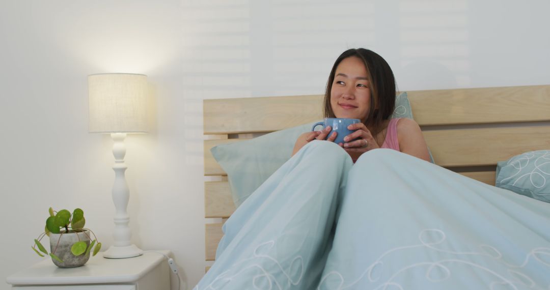 Young Woman Relaxing in Bed with Coffee in Modern Bedroom - Free Images, Stock Photos and Pictures on Pikwizard.com