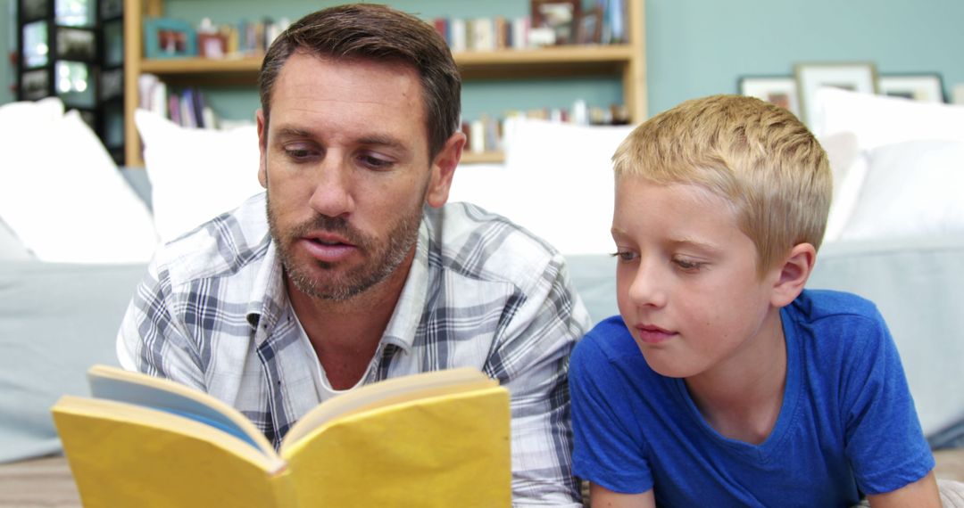 Father Reading Book with Young Son on Floor of Cozy Living Room - Free Images, Stock Photos and Pictures on Pikwizard.com